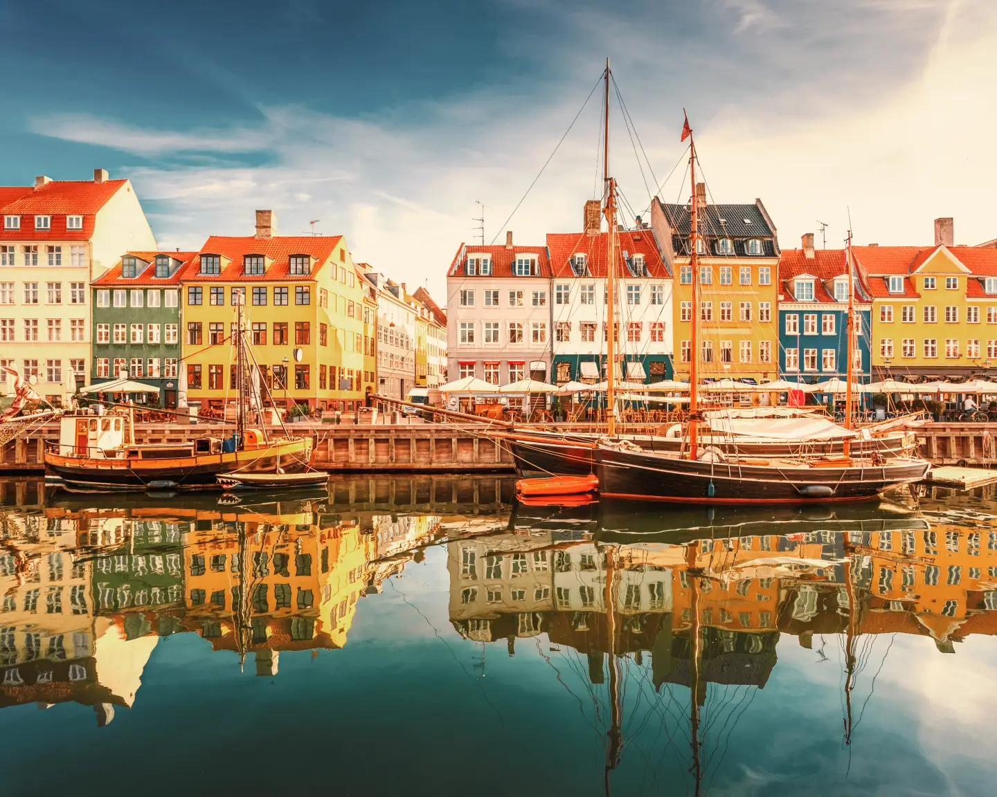 Coloridas hileras de casas y barcos del histórico barrio portuario de Nyhavn, en Copenhague (Dinamarca), se reflejan en las tranquilas aguas.