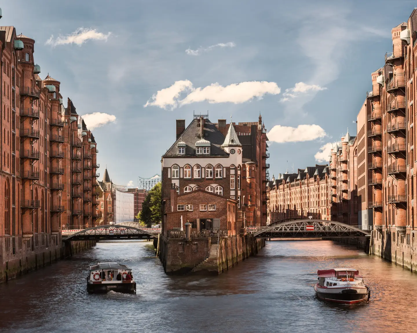 Speicherstadt en Hamburgo, con edificios históricos de ladrillo y barcos en los canales.