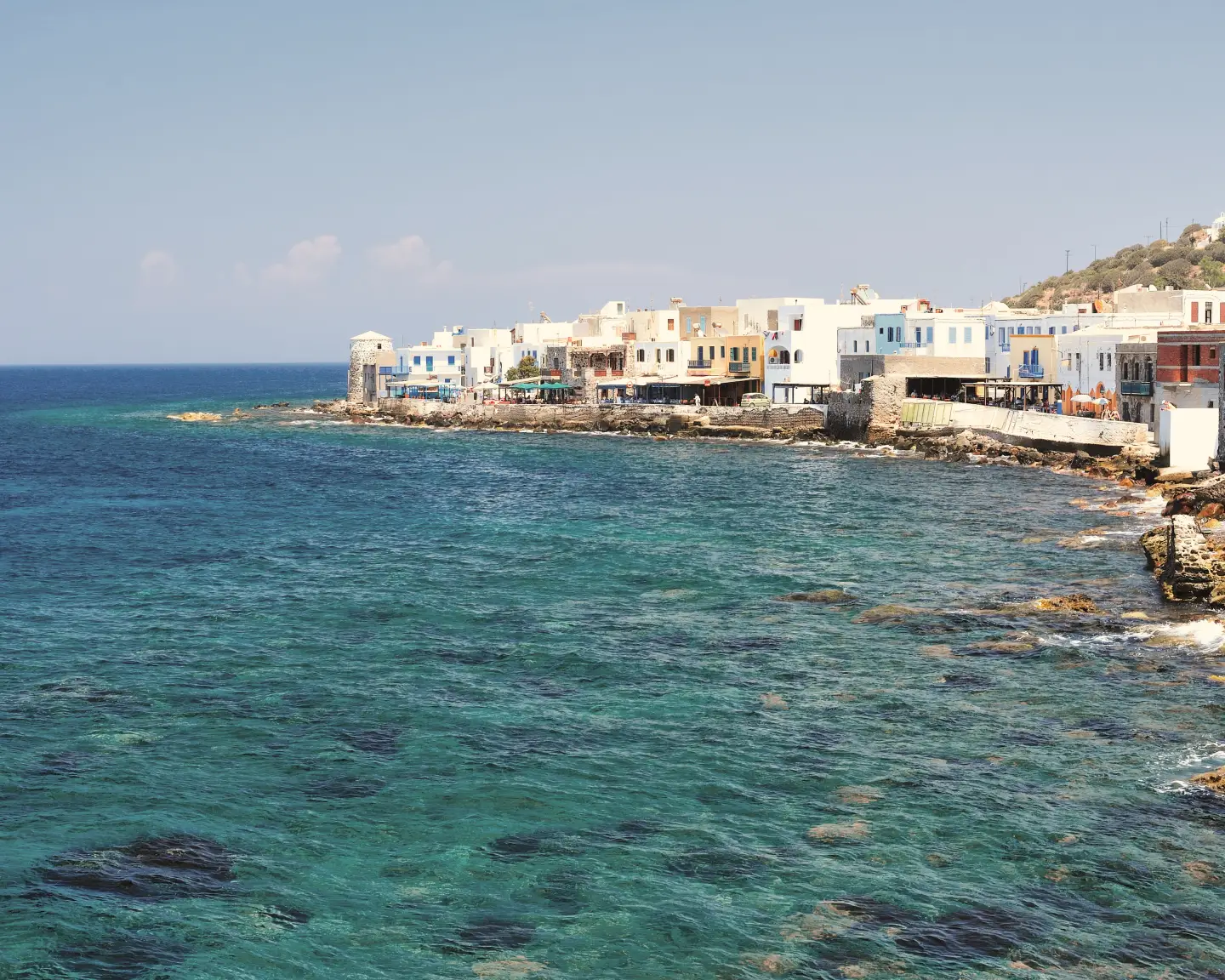 Uitzicht op de kust van het eiland Kos, Griekenland, met traditionele huizen langs de helderblauwe zee.