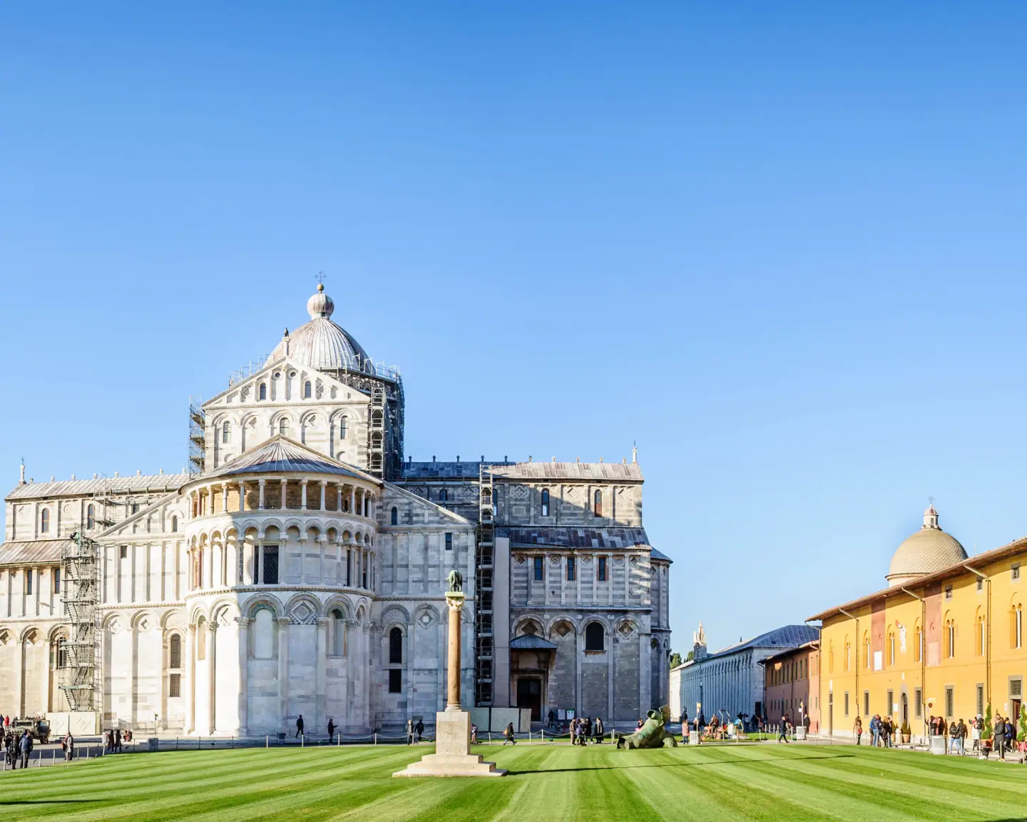 The Leaning Tower of Pisa and the cathedral in Piazza dei Miracoli on a sunny day.