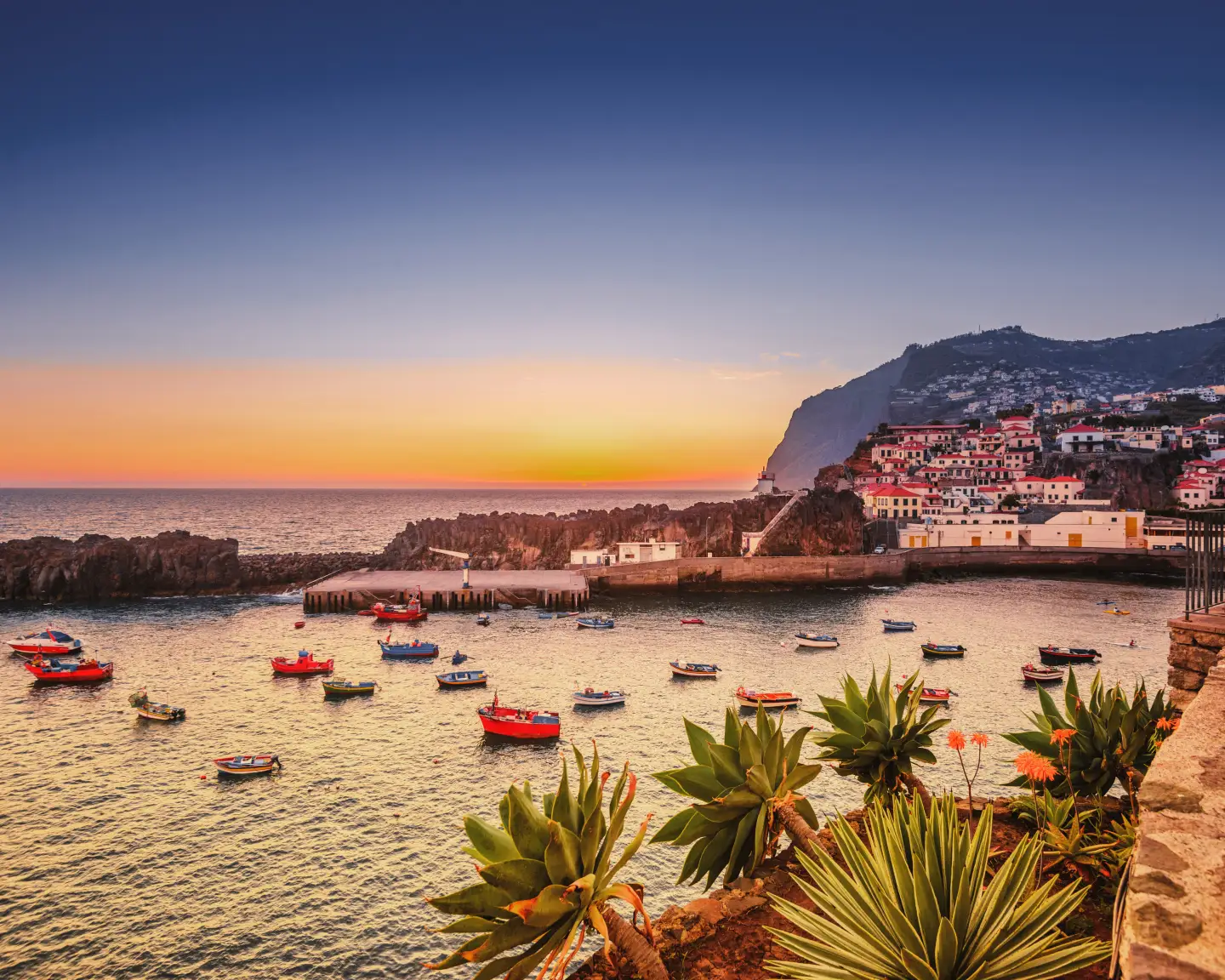 Fischerdorf Camara de Lobos auf der portugiesischen Insel Madeira bei Sonnenuntergang. Im Hintergrund das Wahrzeichen Cabo Girão.