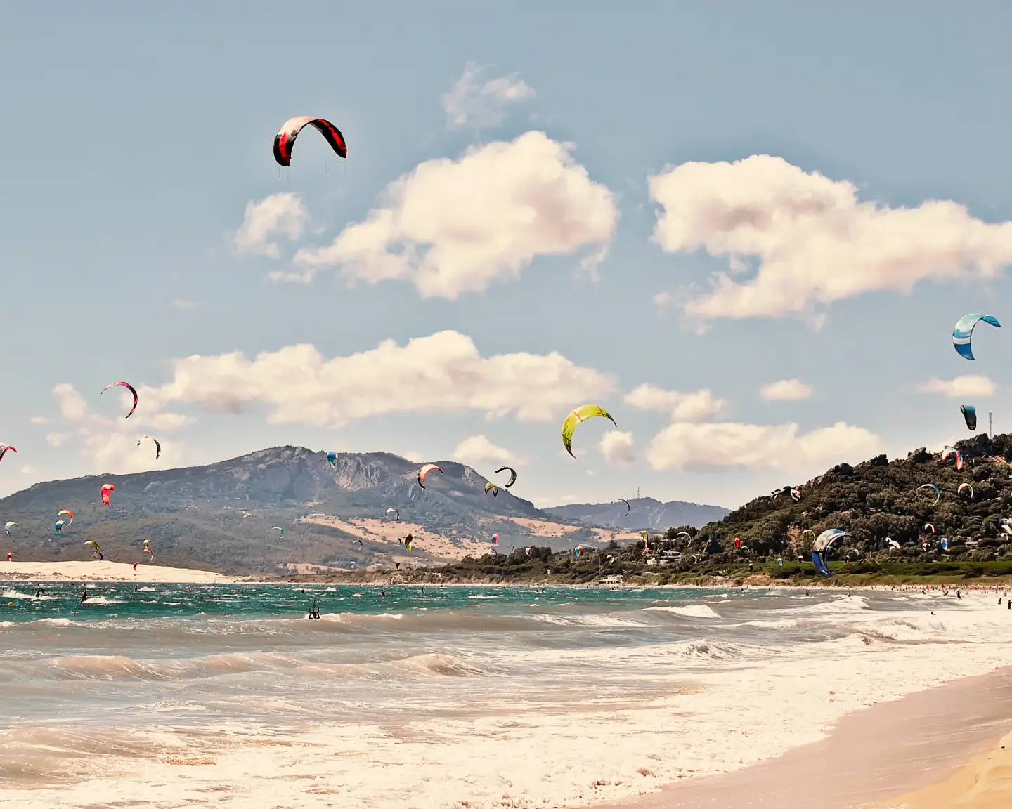 Aficionados al kitesurf en la playa de Tarifa, España, Europa. Un lugar perfecto para los aficionados al kitesurf. Al fondo, se pueden ver las dunas de Las Dunas. El único lugar de Europa con dunas de arena.