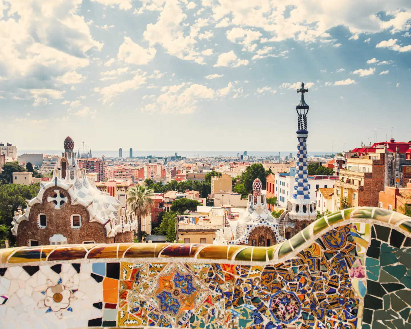 View of Barcelona from Park Güell with the famous mosaic bench in the foreground.