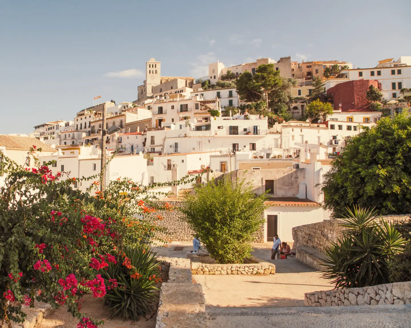 The old part of Ibiza Town with white buildings and flowers in the summer.